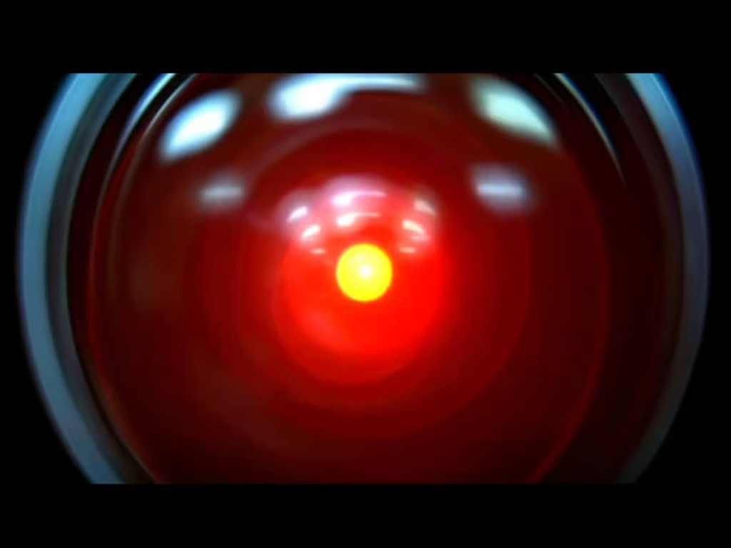 Lentille d'objectif noir avec un centre rougeoyant, figurant le personnage de l'intelligence artificielle HAL9000 dans le film 2001, l'Odyssée de l'espace.