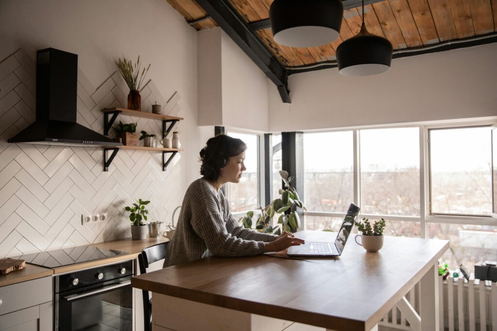 Femme travaillant sur son ordinateur portable dans sa cuisine